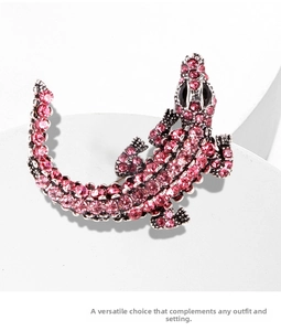 Detailed close-up of a vintage silver crocodile brooch featuring pink rhinestones and black eyes