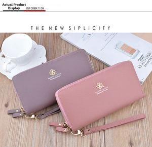 Close-up of dual-zipper litchi texture wallets with gold clover logo and wrist strap
