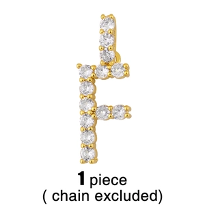 Détail macro du pendentif lettre F avec strass en cristal sur fond blanc pur
