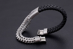 Detail of double stainless steel chains and woven leather bracelet with magnetic clasp