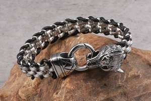 Detailed view of stainless steel wolf head clasp on a braided leather men's bracelet