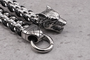 Detailed view of the antique silver wolf head buckle and black woven leather strap