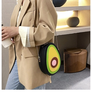 Detail of creative avocado-shaped PU leather crossbody bag with golden metal chain strap