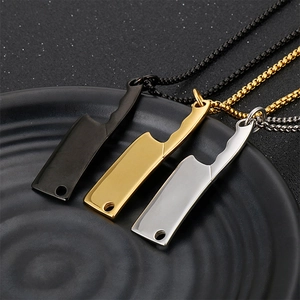 Macro shot of mini chef knife pendants in black, gold, and silver stainless steel