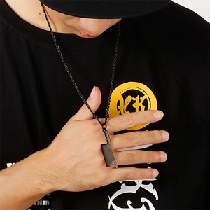 Close-up of a black stainless steel mini cleaver pendant on a twist chain necklace