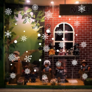 Close-up of white snowflake and dot static stickers on a festive shop glass window