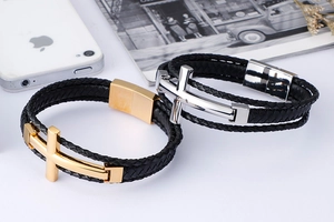 Detail of layered black woven leather bracelets with silver and gold cross magnetic clasps