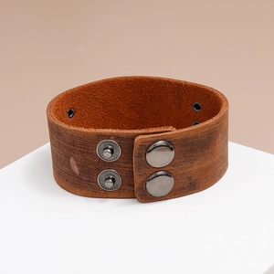 Close-up of vintage brown leather bracelet texture with metal snap button closure details