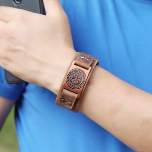 Detail of vintage brown leather Viking compass bracelet with bronze runic metal plate