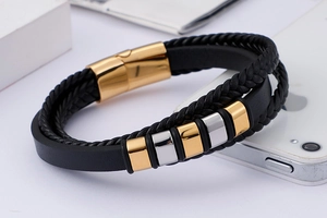 Détail du bracelet multicouche en cuir tressé noir avec fermoir magnétique doré