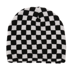 Detailed close-up of a black and white checkerboard knit beanie with ribbed texture