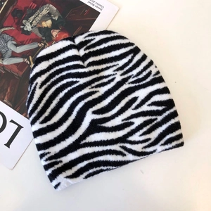 Close-up of black and white knit beanie with zebra pattern on fashion magazine