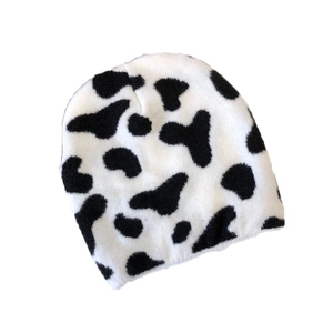 Stylish black and white cow print knitted beanie hat for winter fashion and warmth