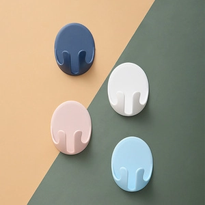 Detail of four colorful oval wall hooks showing double hook structure and minimalist design