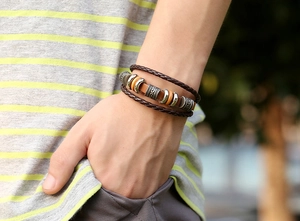 Detail of multi-layer brown braided leather bracelet with vintage alloy beads on wrist