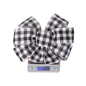 Detail shot of black and white checkered Christmas bow on scale weighing 20.6 grams