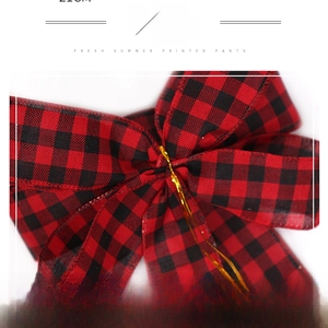 Macro detail of red and black buffalo plaid Christmas bow with wire-edged ribbon for DIY