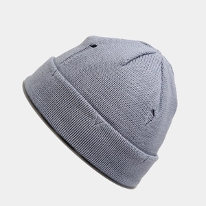 Detailed knit texture and distressed ripped design on light blue-grey street beanie