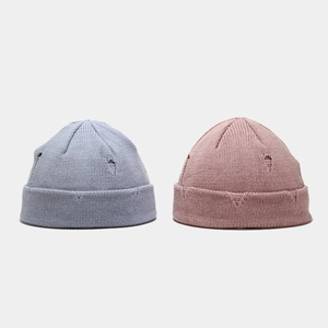 Distressed knit beanies in grey-blue and dusty rose colors with ripped hole design