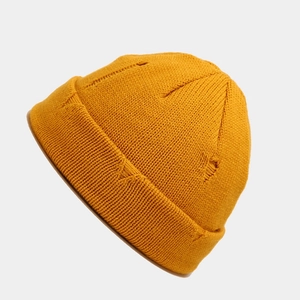 Close-up of mustard yellow distressed knit beanie featuring vintage ripped street style texture