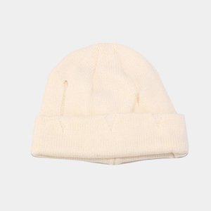 Close-up of cream white knitted beanie showing detailed core-spun yarn texture and rolled edge