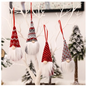 Detail of four knitted Christmas gnomes with long beards hanging on white branches