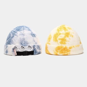 Blue and yellow tie-dye knit docker cap with adjustable strap and brand tag detail