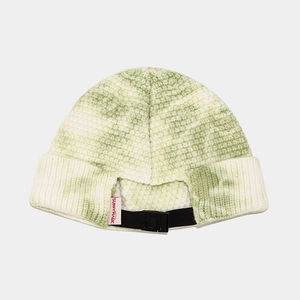 Close-up of tie-dye knit beanie featuring a pink brand label and black adjustable buckle