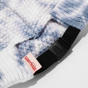 Close-up of blue tie-dye knit hat with adjustable black strap and brand label