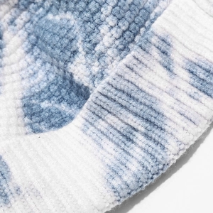 Close-up detail of the soft blue and white tie-dye knit texture of this trendy beanie