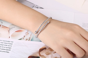 Detailed close-up of a silver twisted cable cuff bracelet in polished stainless steel