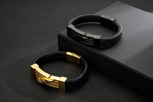 Detail of woven leather bracelets with black and gold stainless steel clasps on a display box