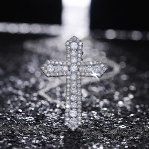 Vue macro d'un pendentif croix de luxe pavé de zircons sur texture noire