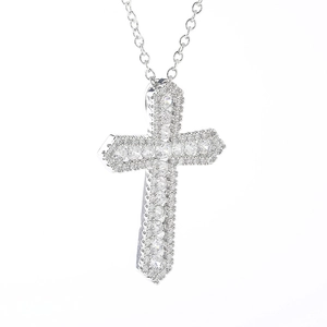 Détail macro du pendentif croix argenté avec micro-pavage de pierres de zircone