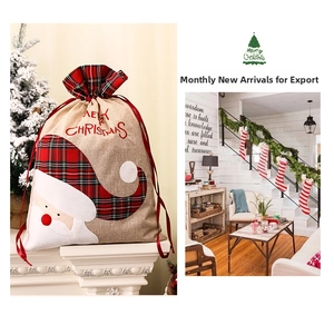 Detail of burlap Christmas gift bag featuring Santa Claus and red plaid pattern design