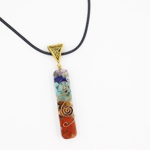 Macro detail of 7-chakra resin pendant with copper spiral and multi-color natural stones