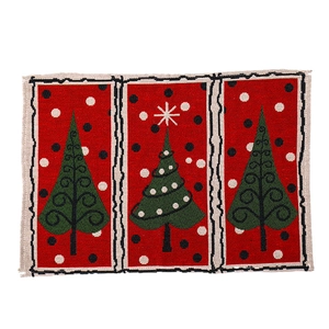 Red jacquard Christmas placemat featuring three green festive trees on a white background