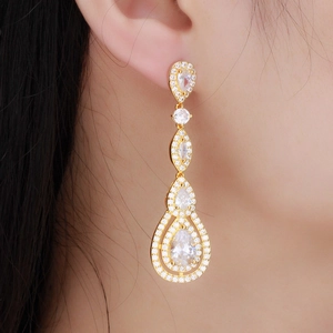 Elegant gold drop earrings with AAA zirconia and pear-shaped crystals on model