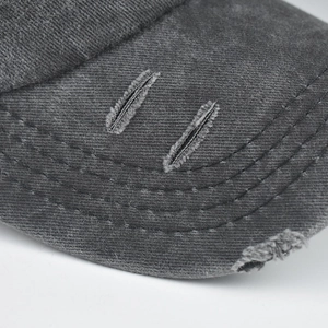 Gros plan d'une casquette en coton délavé avec détails déchirés et coutures sur la visière