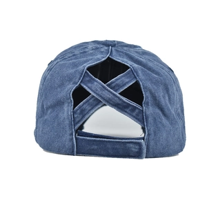 Détail d'une casquette en denim bleu avec bandes élastiques croisées pour queue de cheval