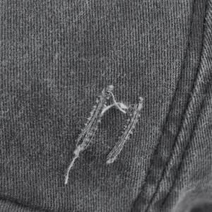 Détail macro du tissu denim gris foncé avec des coutures blanches effet usé
