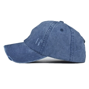 Détail de la casquette en jean délavé avec broderie IF et bordure à effet usé