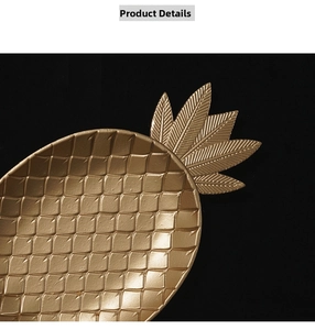 Detailaufnahme des goldenen Ananas-Tabletts mit geschnitztem Blatt und Netzstruktur
