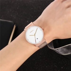 Close-up of rose gold watch with Milanese band and date window on female wrist