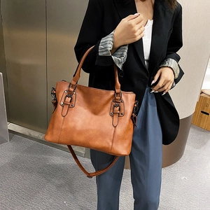 Brown textured leather tote bag with top handles and adjustable shoulder strap for women