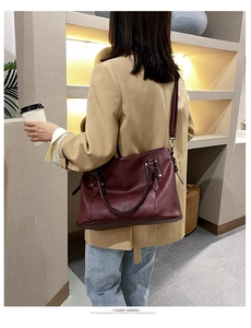 Classic fashion burgundy leather tote bag shown being worn as a shoulder bag in lifestyle setting