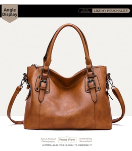 Detailed view of brown retro tote bag with lychee grain texture and metal buckles