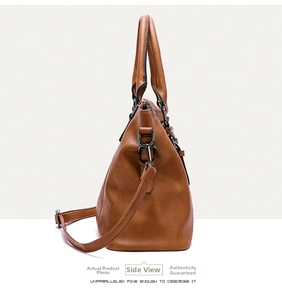 Detailed side view of brown leather handbag with silver buckles and adjustable strap