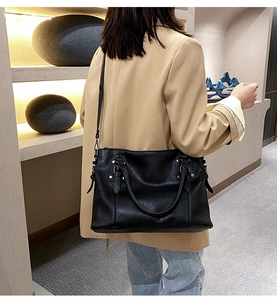 Detail of black pebbled leather tote featuring silver hardware and a removable shoulder strap