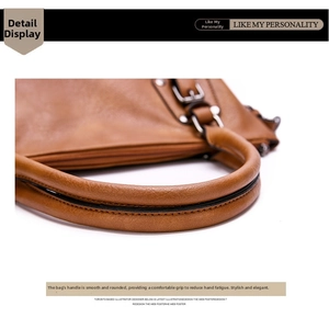 Detail of tan leather handbag handle with sleek black edges and premium metal hardware